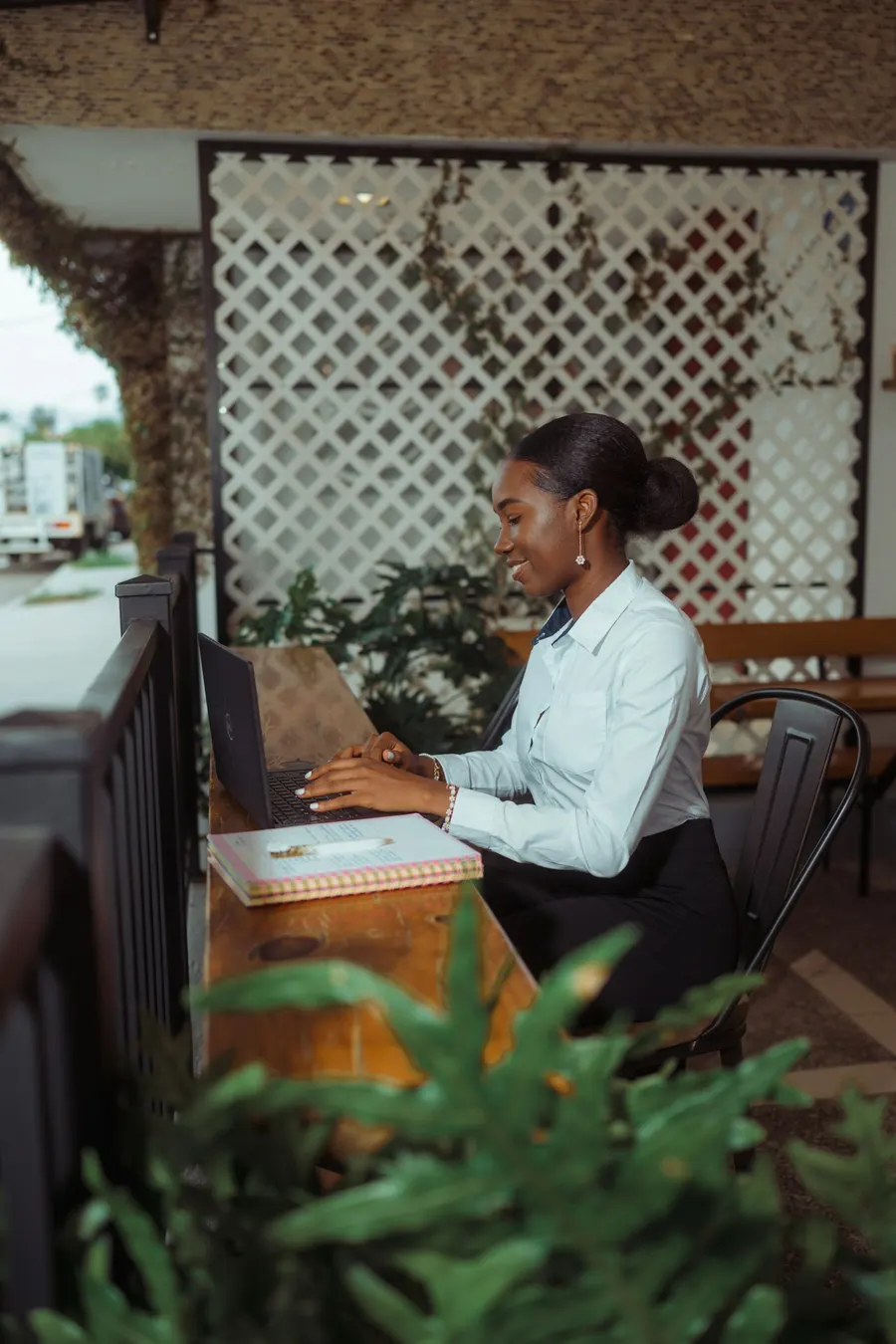 A café owner smiles while working on a laptop